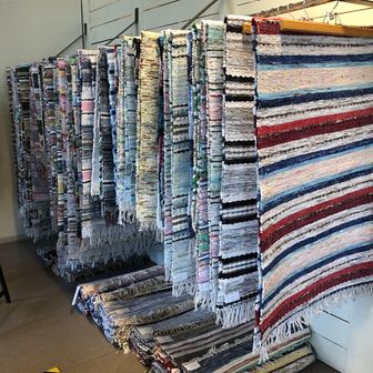 Over 100 woven and fringed rag rugs in various traditional patterns.